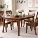 Dining room with wooden table and chairs, flowers, and decor.