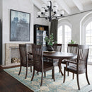 Dining room with wooden table and chairs, fireplace, and large windows.