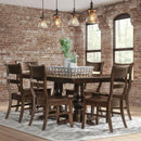 Dining room with wooden table and chairs against a brick wall.
