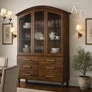 Wooden china cabinet with glass doors displaying dishes in a room with wall sconces and a plant.