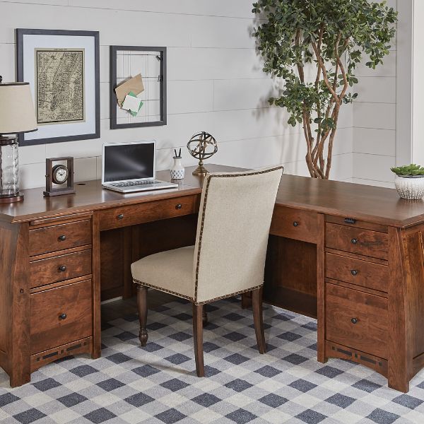 Traditional style Boulder Creek L-shaped desk with wood finish, featuring a sit-to-stand adjustable drawer on the left and a pencil drawer on the right, with a desk chair in front.