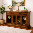 Wooden sideboard with decorative items in a room with a painting on the wall.