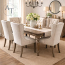 Dining room with wooden table and upholstered chairs, featuring a chandelier and decorative elements.