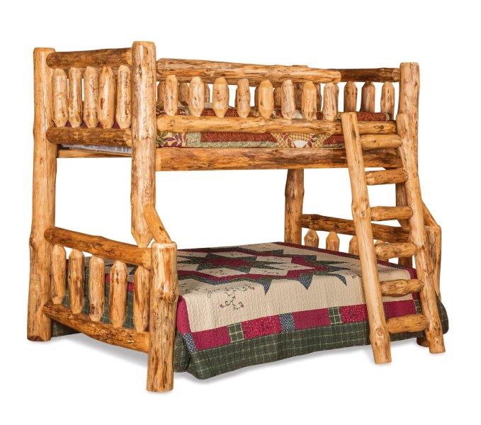 A rustic full-twin bunk bed with the lower bunk featuring a multicolored quilt and the upper bunk having a solid, natural wood finish.