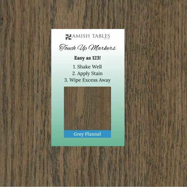 A Grey Flannel Touch Up Marker packaging card placed on a wooden surface, with instructions for use.