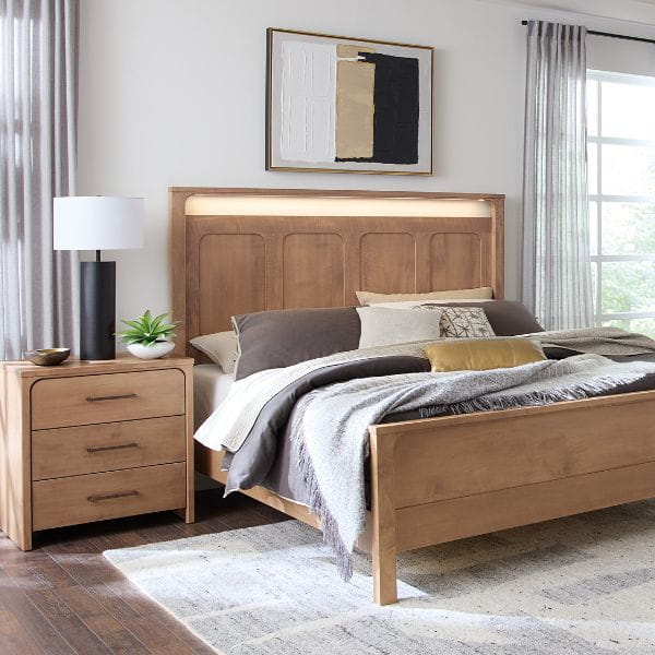 Wooden bed with headboard lighting in a bedroom setting