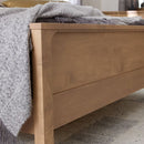 Wooden bed frame with a textured gray blanket draped over it