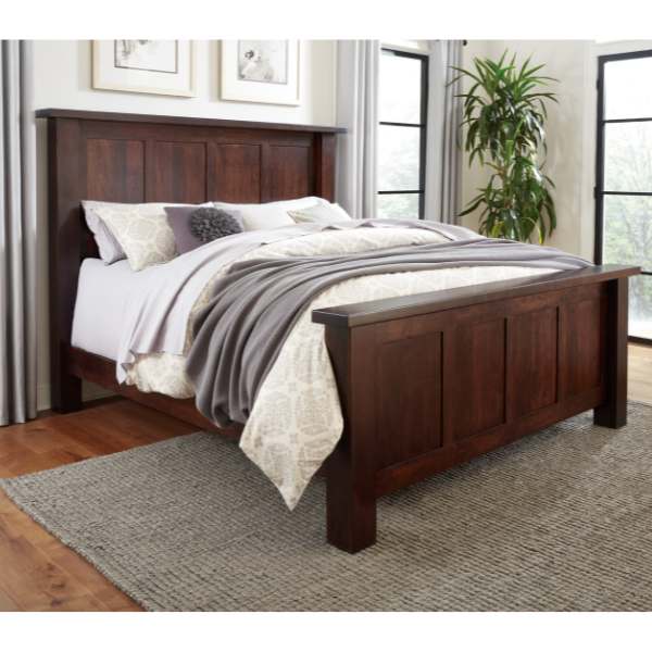 A contemporary style bed with a dark wood headboard and footboard, made in a room with a light decor.