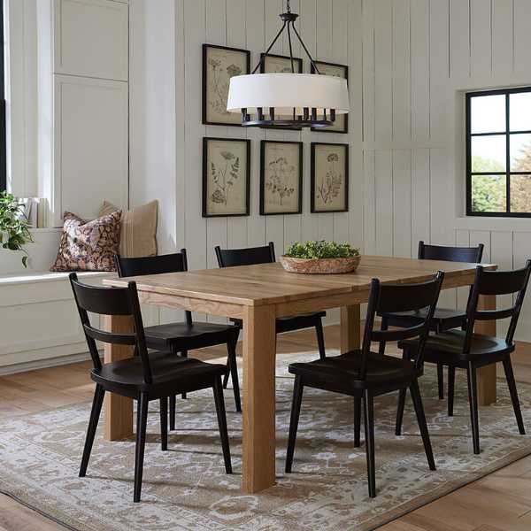 A solid wood dining chair with a dark stain finish, shown in a side view highlighting the chair&
