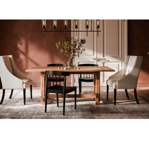 brown dining room wall. A wooden table with 2 white head chairs and 3 black side chairs.