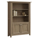 A brown wooden bookcase with adjustable shelves and bottom doors, made in a Shaker style with a touch of Mission style.