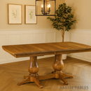 Wooden dining table with a classic design in a room with framed artwork and a plant.