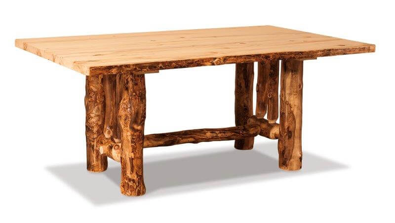 A rustic trestle dining table made of solid wood with a clear coat stain finish, featuring natural knots and patterns typical of rustic log style furniture.