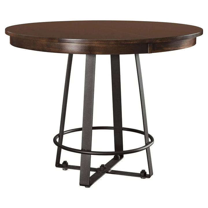 Round wooden dining table with a dark brown wood top and a black metal pedestal base with a circular footrest ring, shown on a plain white background.