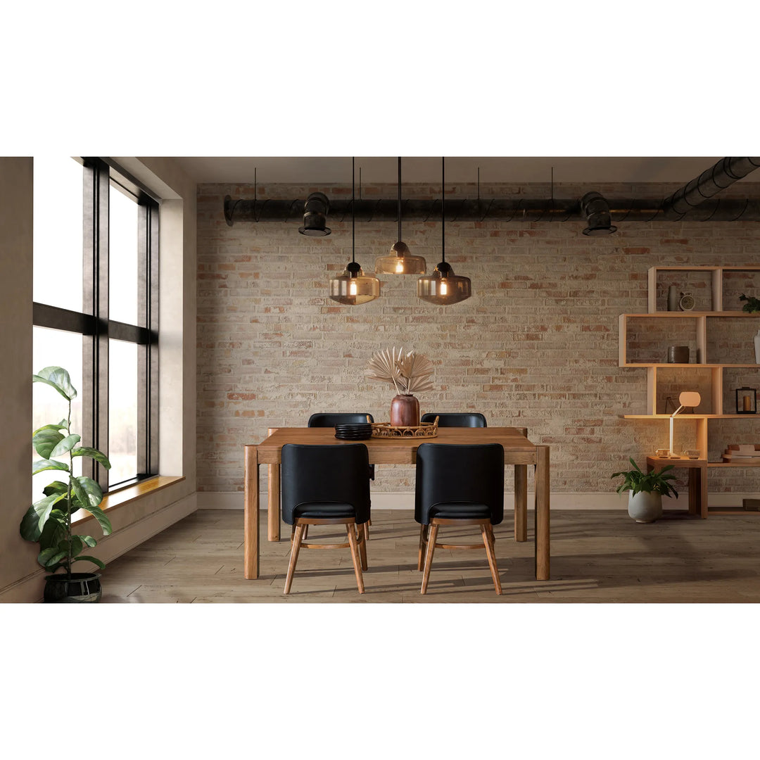 A modern dining room setup featuring a rectangular light oak wood table with four black upholstered chairs with light wood legs, set against a rustic brick wall with industrial ceiling fixtures and pendant lights.