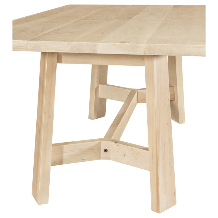 A light natural wood dining table with a thick rectangular top and four sturdy legs, featuring a central X-shaped stretcher brace on the legs, shown against a plain white background.
