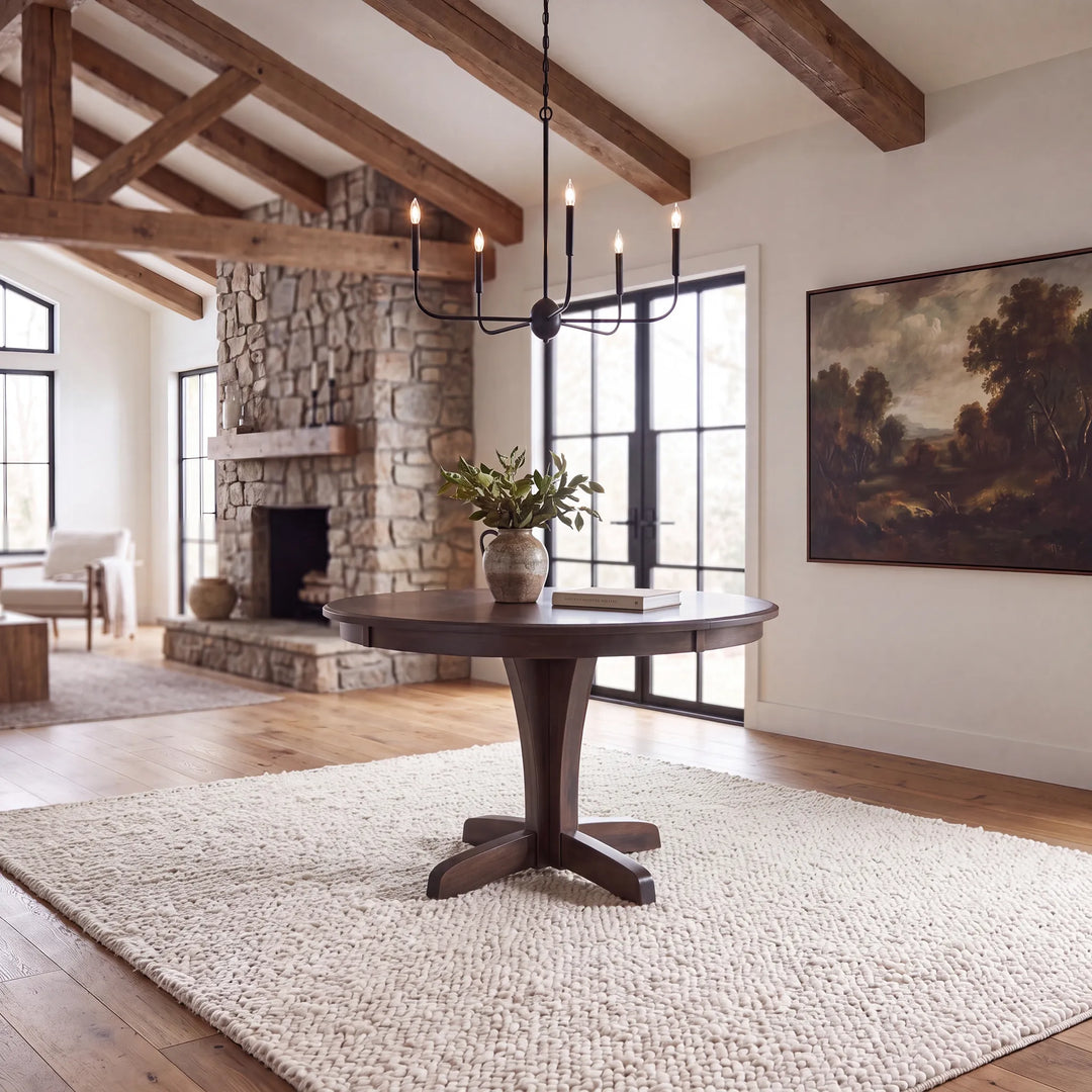 A dark circular table in a rustic brightly lit living room.