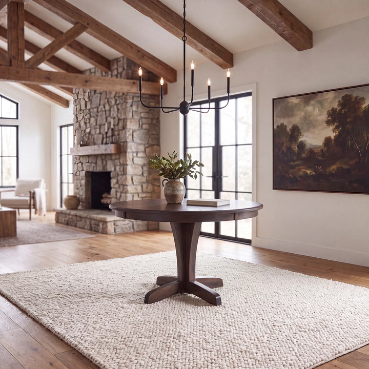 A dark circular table in a rustic brightly lit living room.