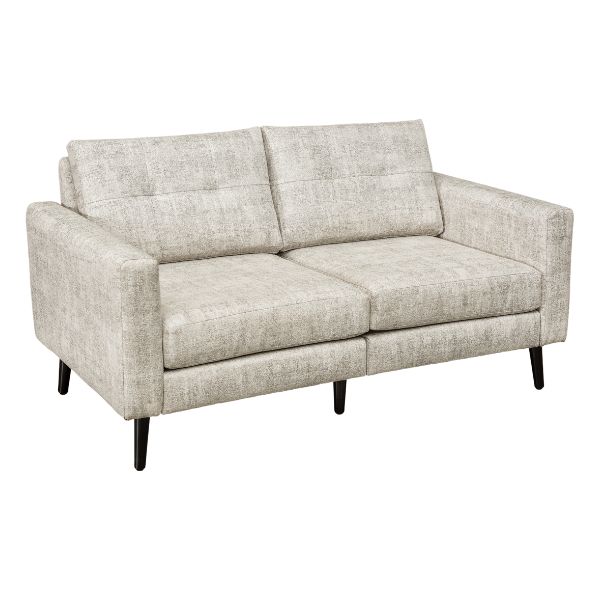 A well-lit living room featuring a beige upholstered sofa set with a design that includes mission lines, alongside a matching armchair and footstool, set on a patterned rug.